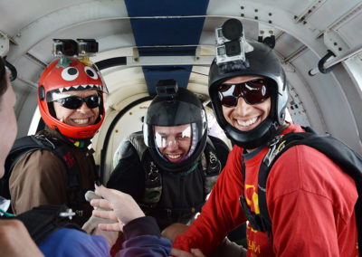 Happy freefall video camera skydivers in PAC-750 airplane at SkyDance SkyDiving Davis, California.